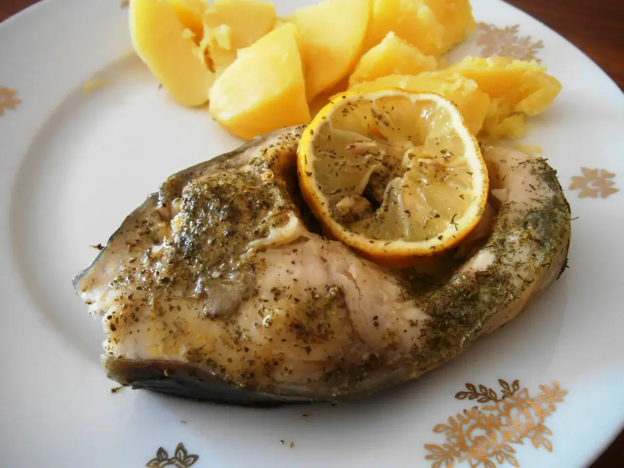 Chrupiący karp z piekarnika, pieczony z cytryną i ziołami, podany z ziemniakami.